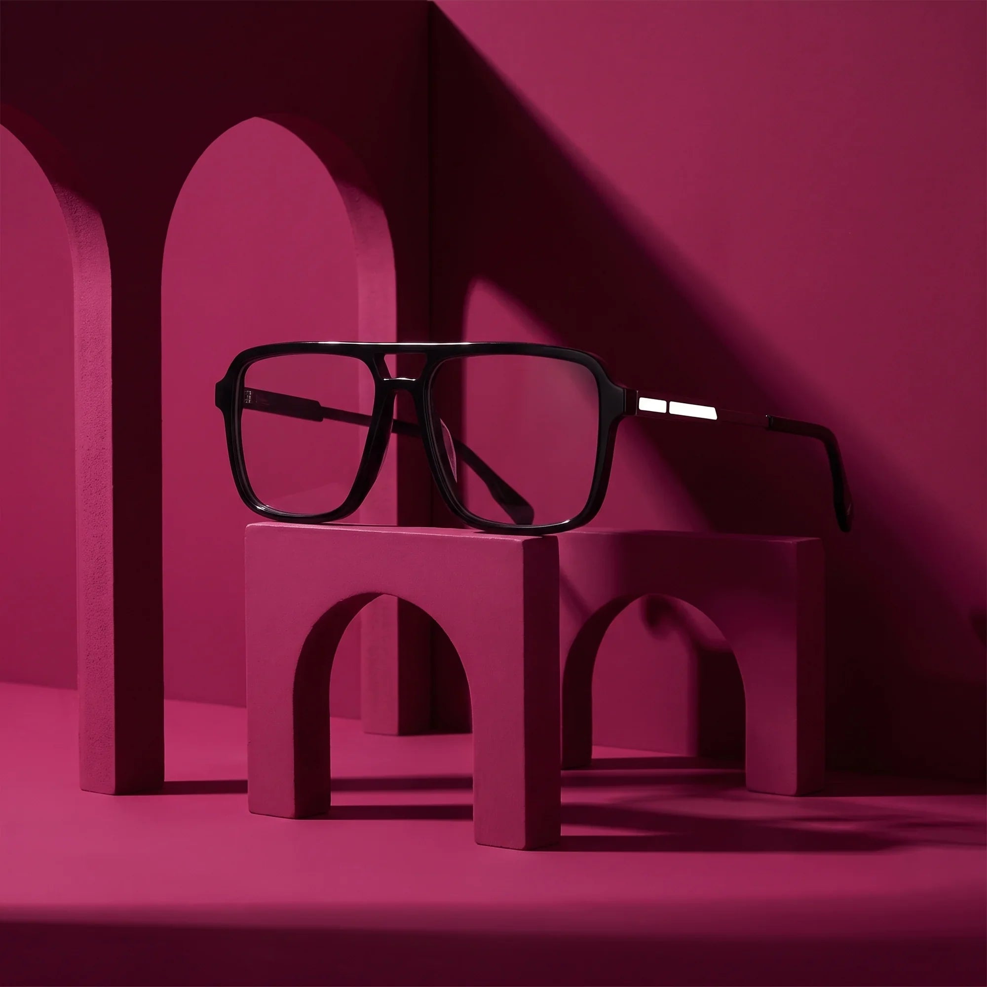 Anteojos Fiore 1014 en negro – staged on a sculptural magenta architecture set