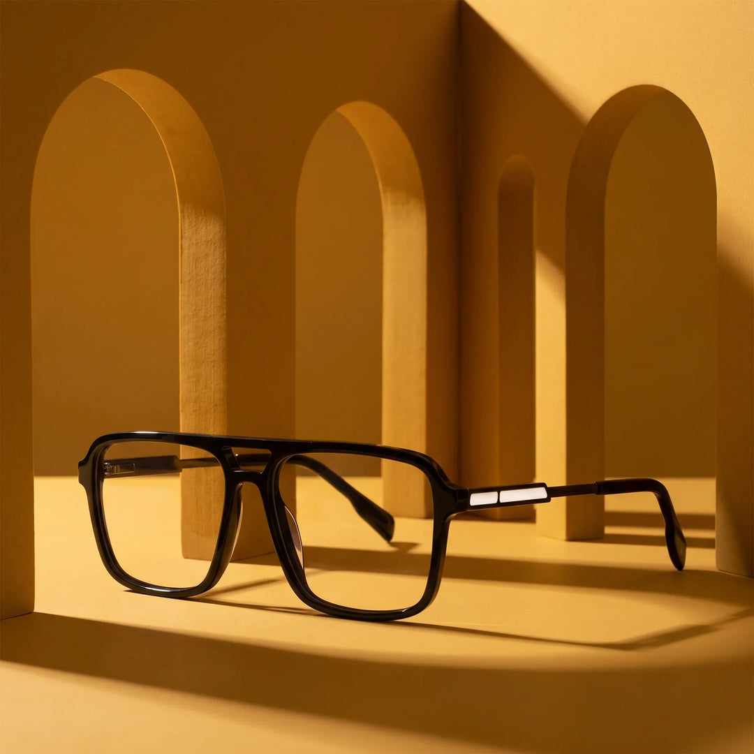 Anteojos Fiore 1014 en negro – displayed on a mustard ochre podium among arches