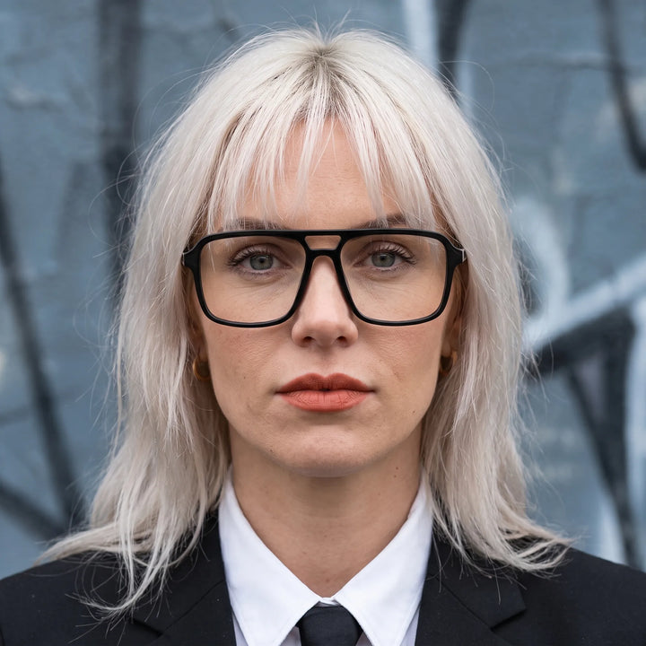 Anteojos Fiore 1014 en negro, en modelo – retrato de campaña, confident portrait with gold chain necklace