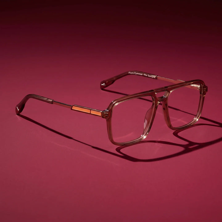 Anteojos Fiore 1014 en café – editorial still life on a saturated burgundy set