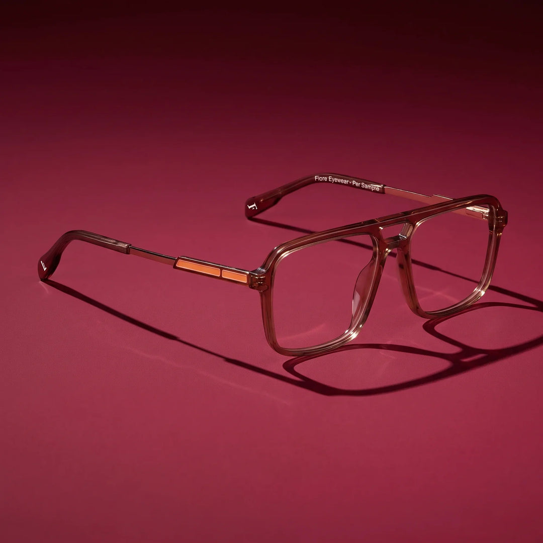 Anteojos Fiore 1014 en café – editorial still life on a saturated burgundy set