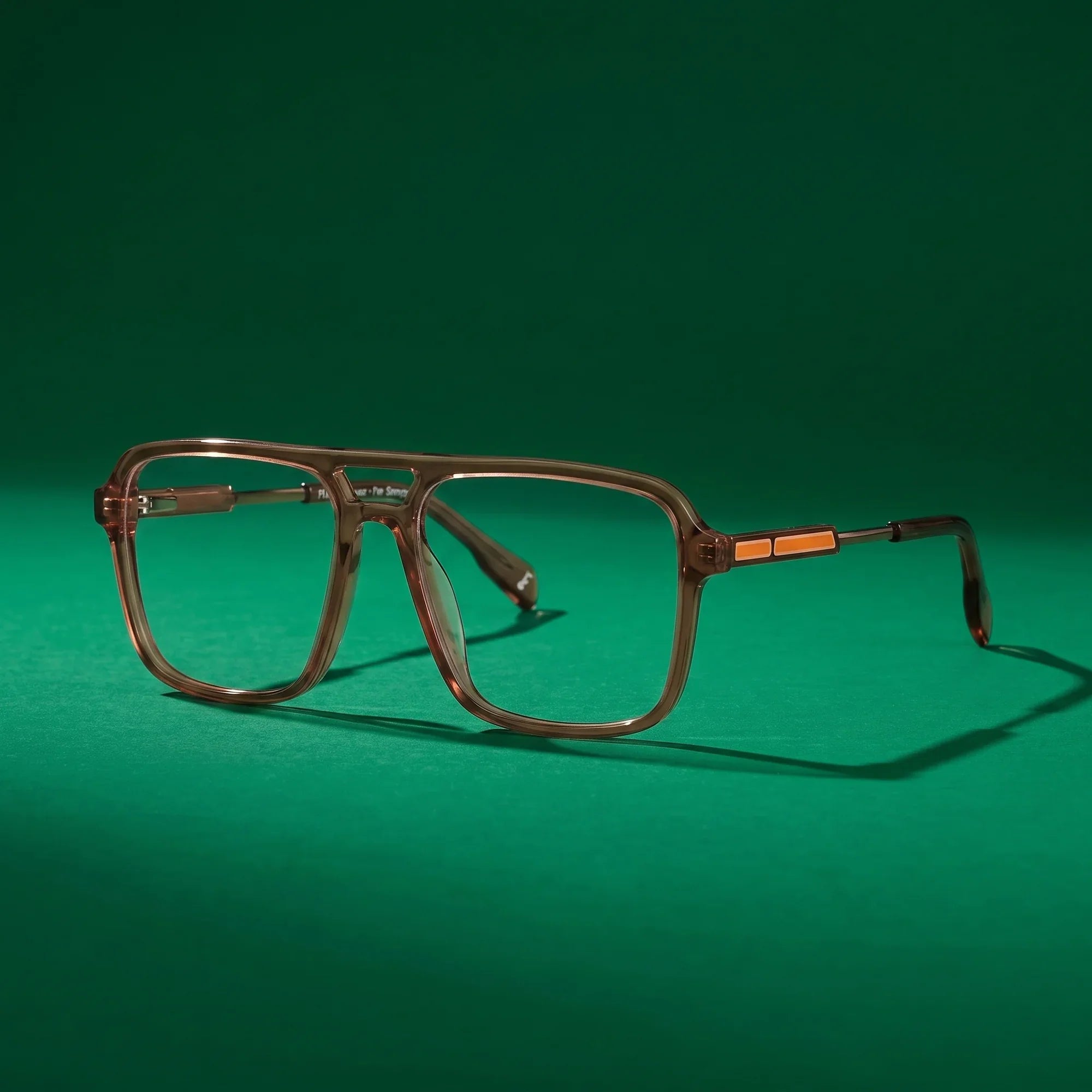 Anteojos Fiore 1014 en café – still life on a seamless emerald studio backdrop