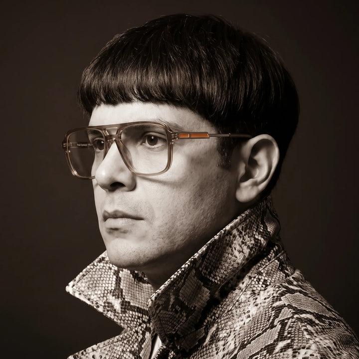 Anteojos Fiore 1014 en café, en modelo – retrato de campaña, monochrome studio portrait, red graphic accents