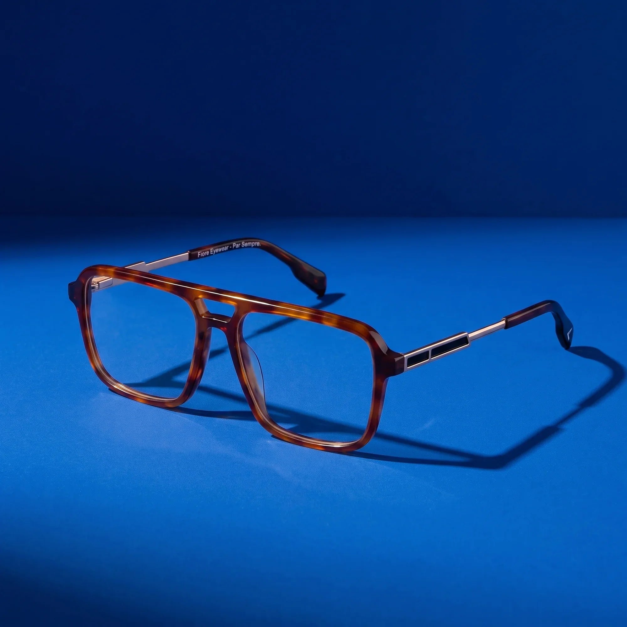 Anteojos Fiore 1014 en brown tortoiseshell – bodegón sobre fondo cobalto de estudio