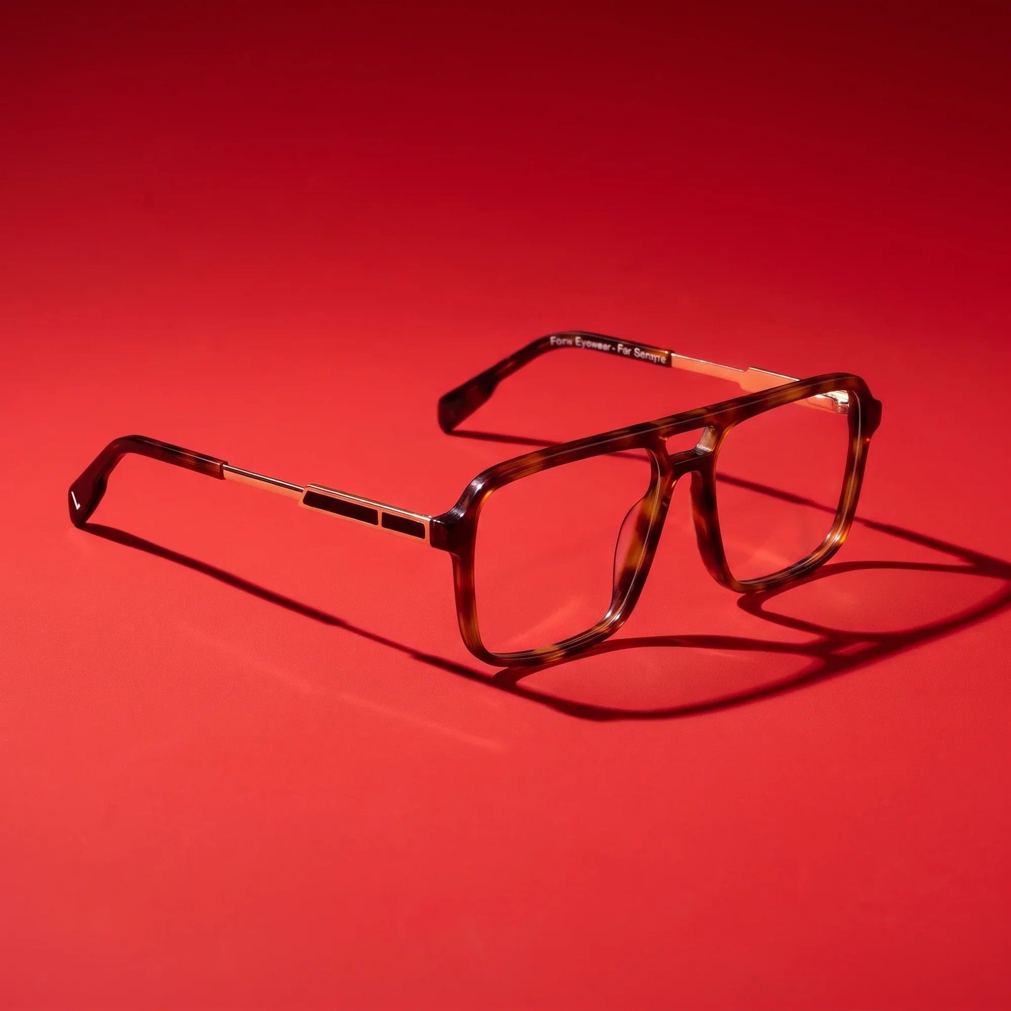 Anteojos Fiore 1014 en brown tortoiseshell – hero still life against a deep vivid red backdrop