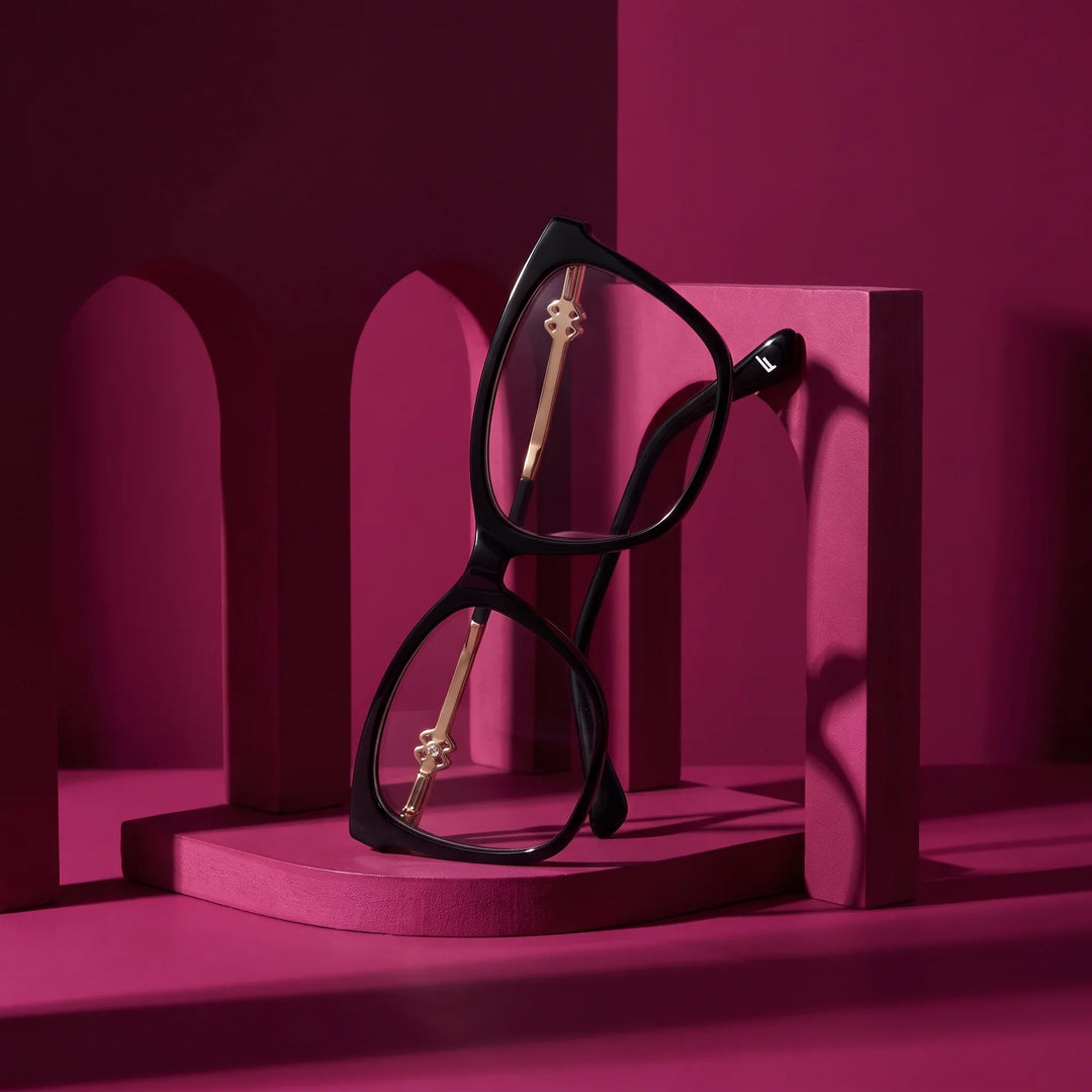 Anteojos Fiore 10172 en negro – staged on a sculptural magenta architecture set