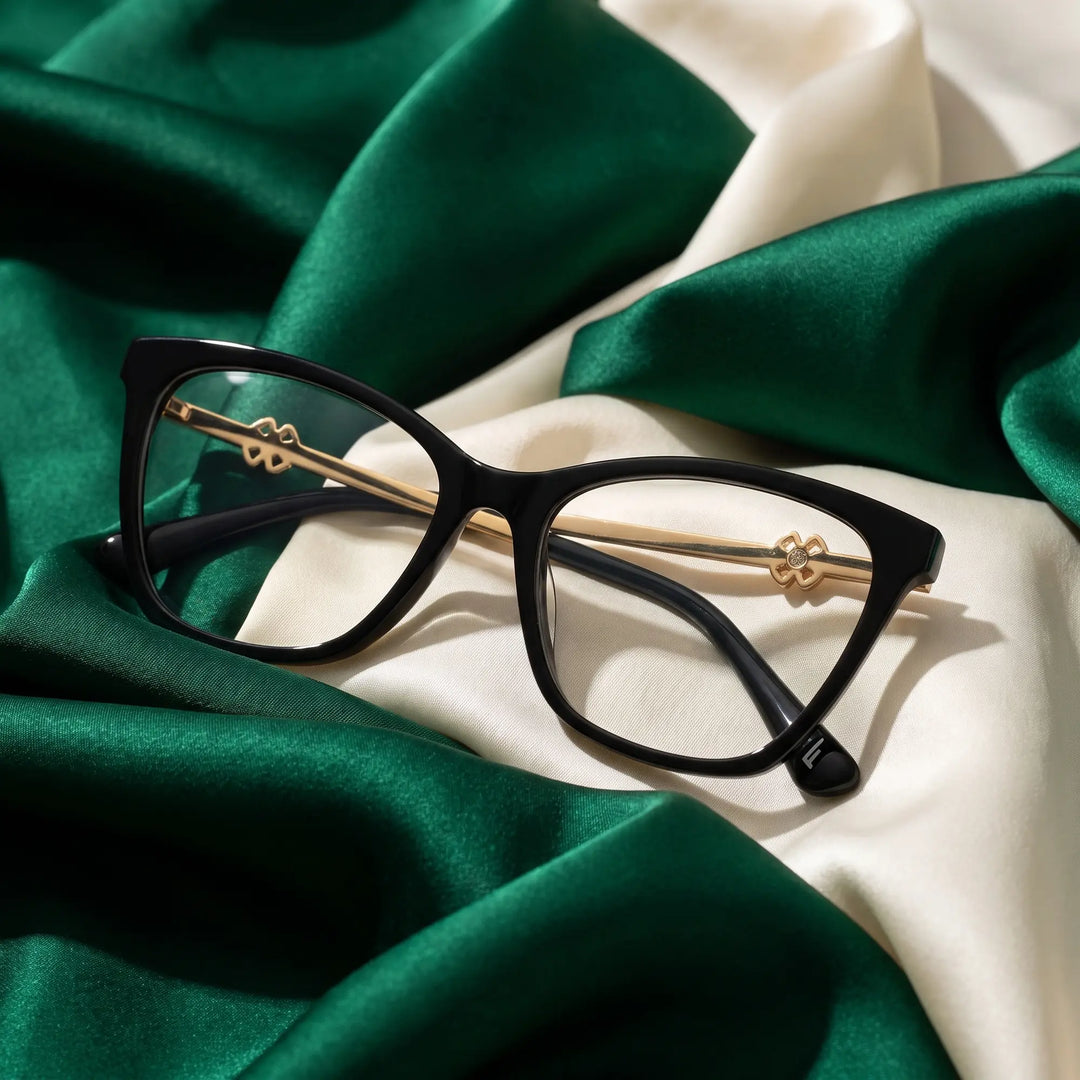 Anteojos Fiore 10172 en negro – resting on draped emerald and ivory silk