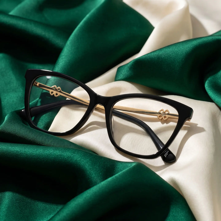 Anteojos Fiore 10172 en negro – resting on draped emerald and ivory silk