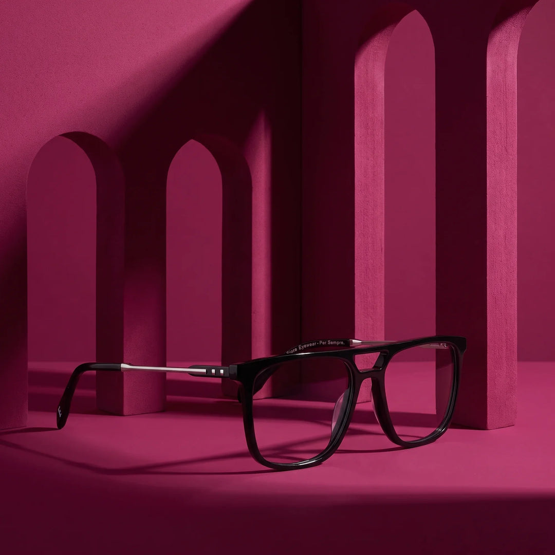Anteojos Fiore 10177 en negro – staged on a sculptural magenta architecture set
