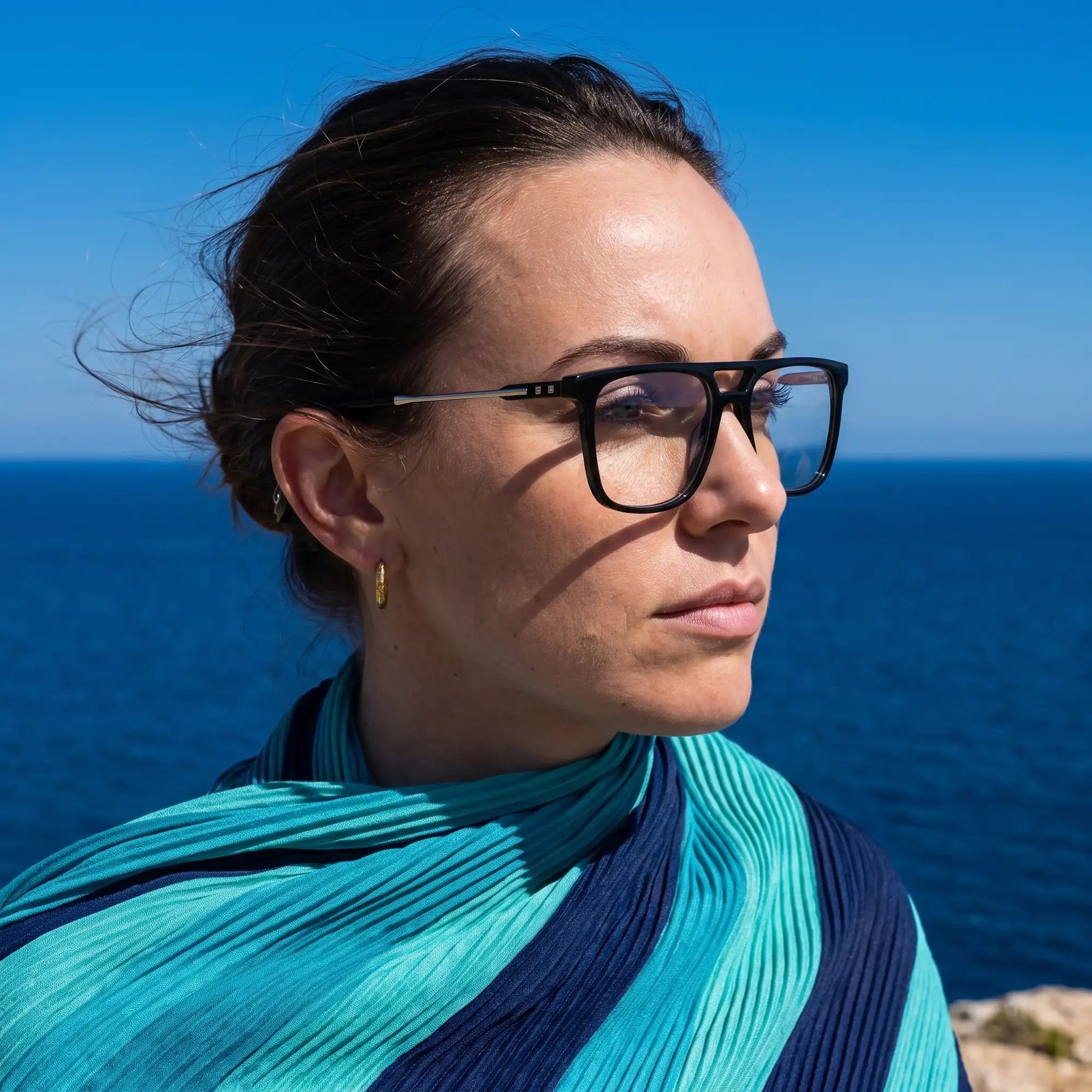 Anteojos Fiore 10177 en negro, en modelo – retrato de campaña, retrato al viento sobre el mar azul profundo