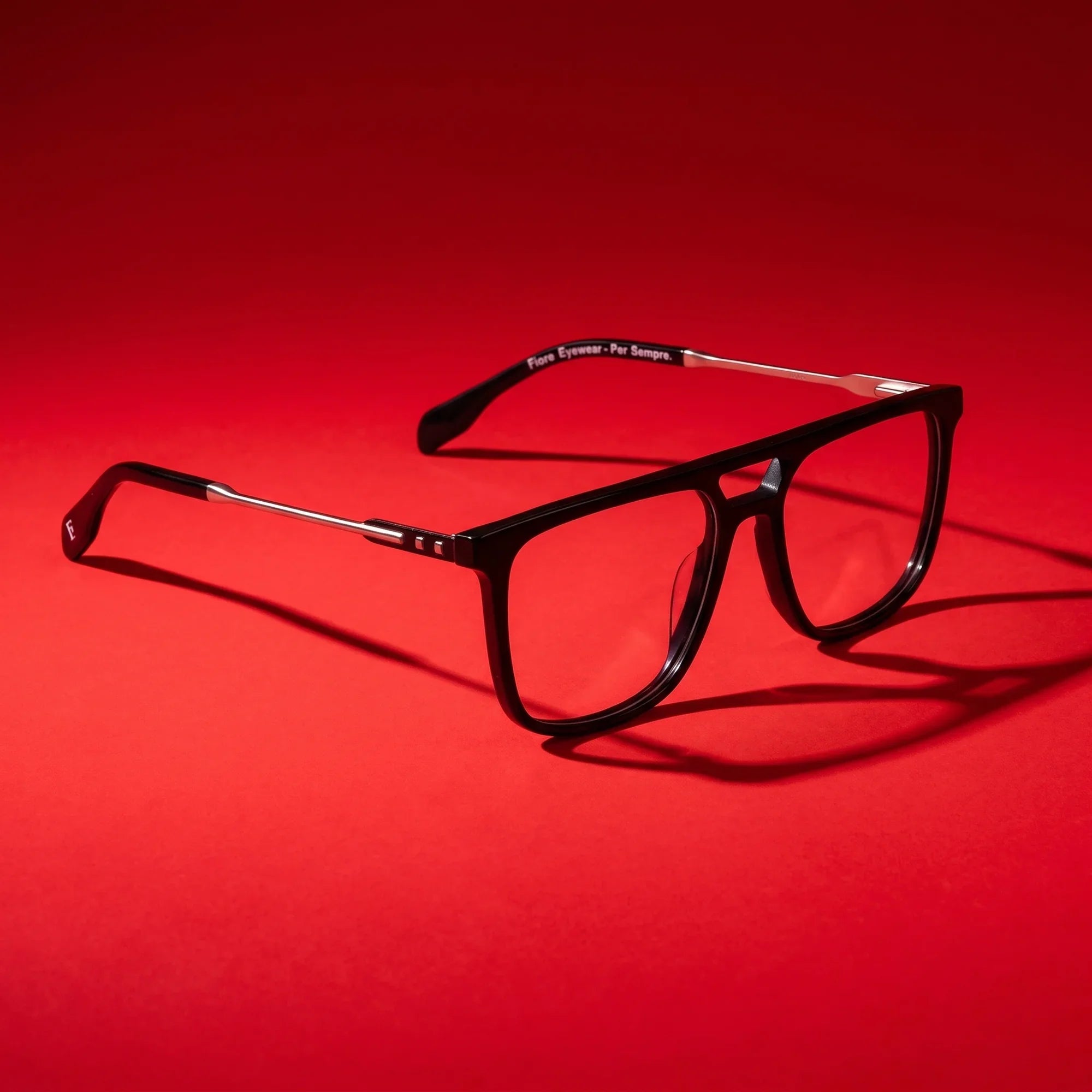 Anteojos Fiore 10177 en negro – editorial still life on a saturated vivid red set