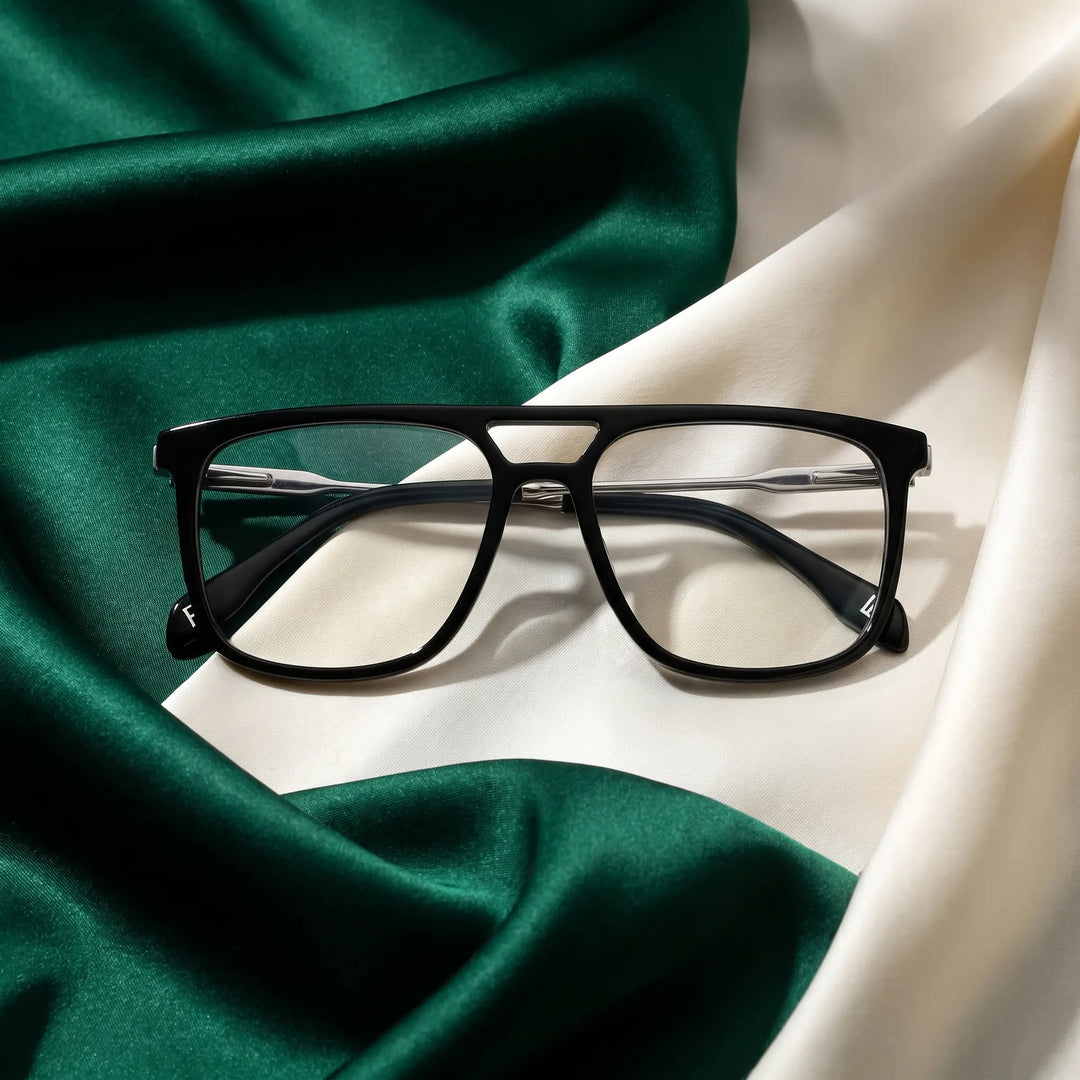Anteojos Fiore 10177 en negro – resting on draped emerald and ivory silk