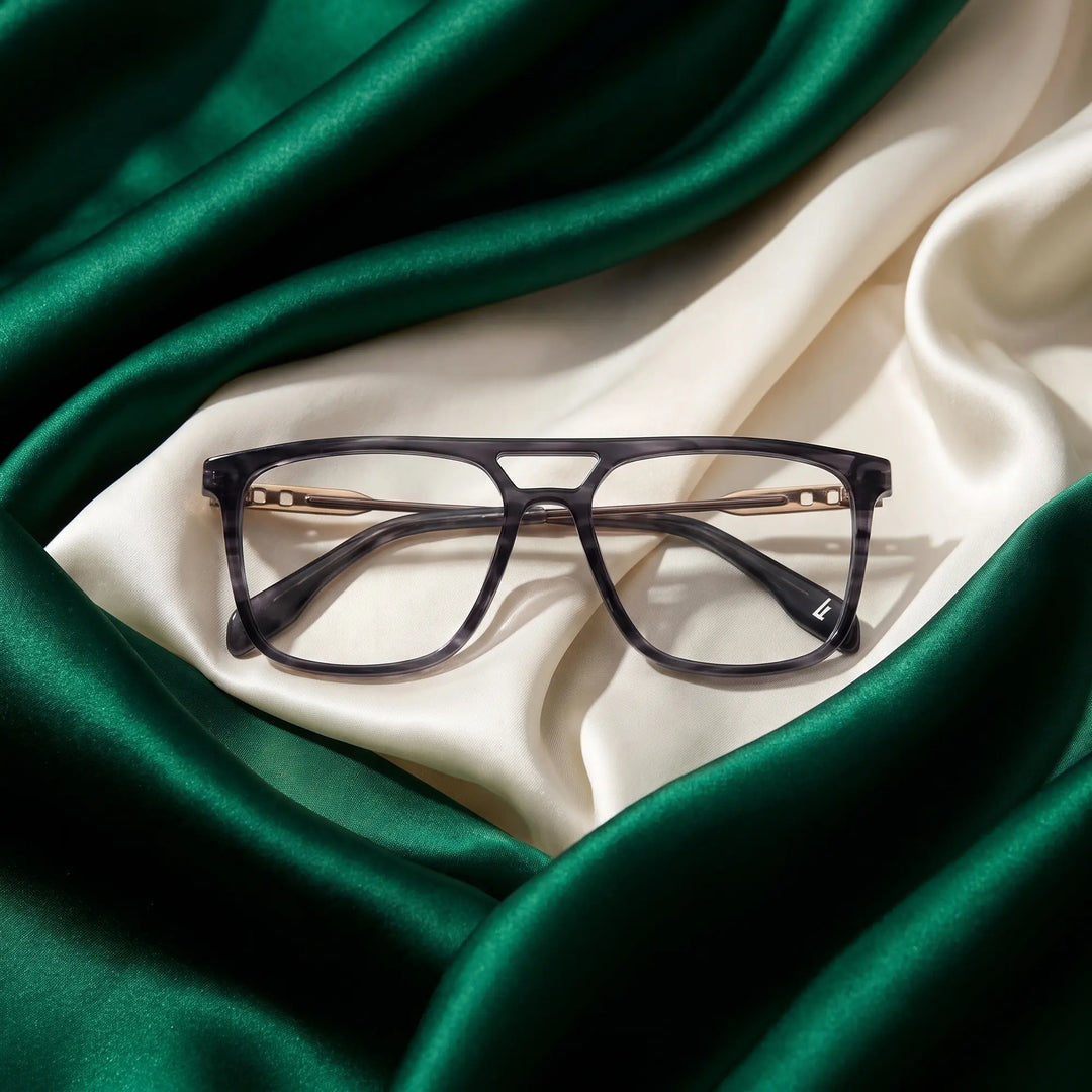 Anteojos Fiore 10177 en gris – resting on draped emerald and ivory silk