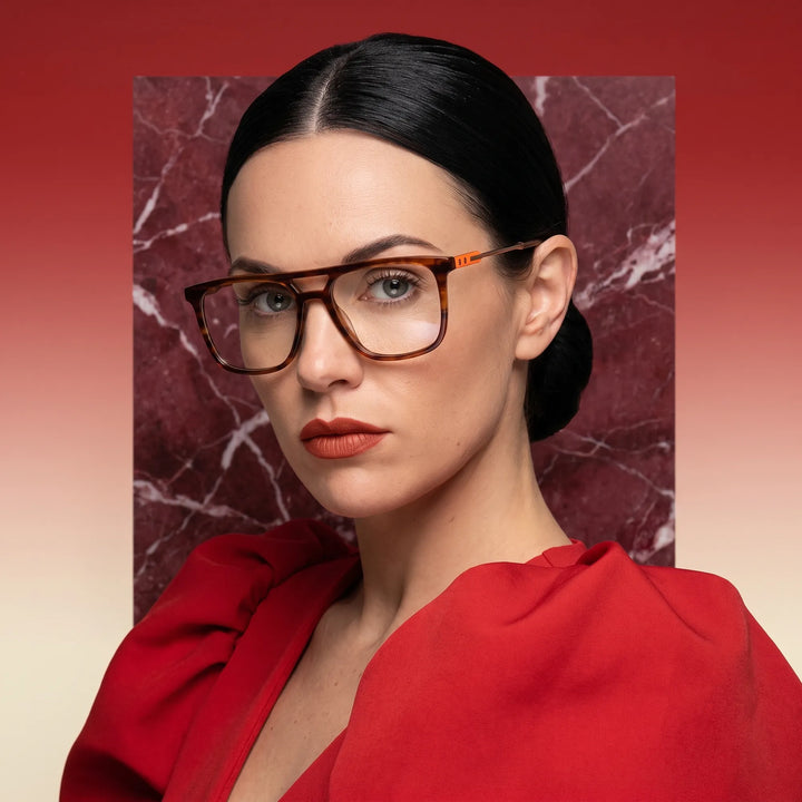 Anteojos Fiore 10177 en tortoiseshell, en modelo – retrato de campaña, fondo de mármol rojo y vestido escarlata drapeado