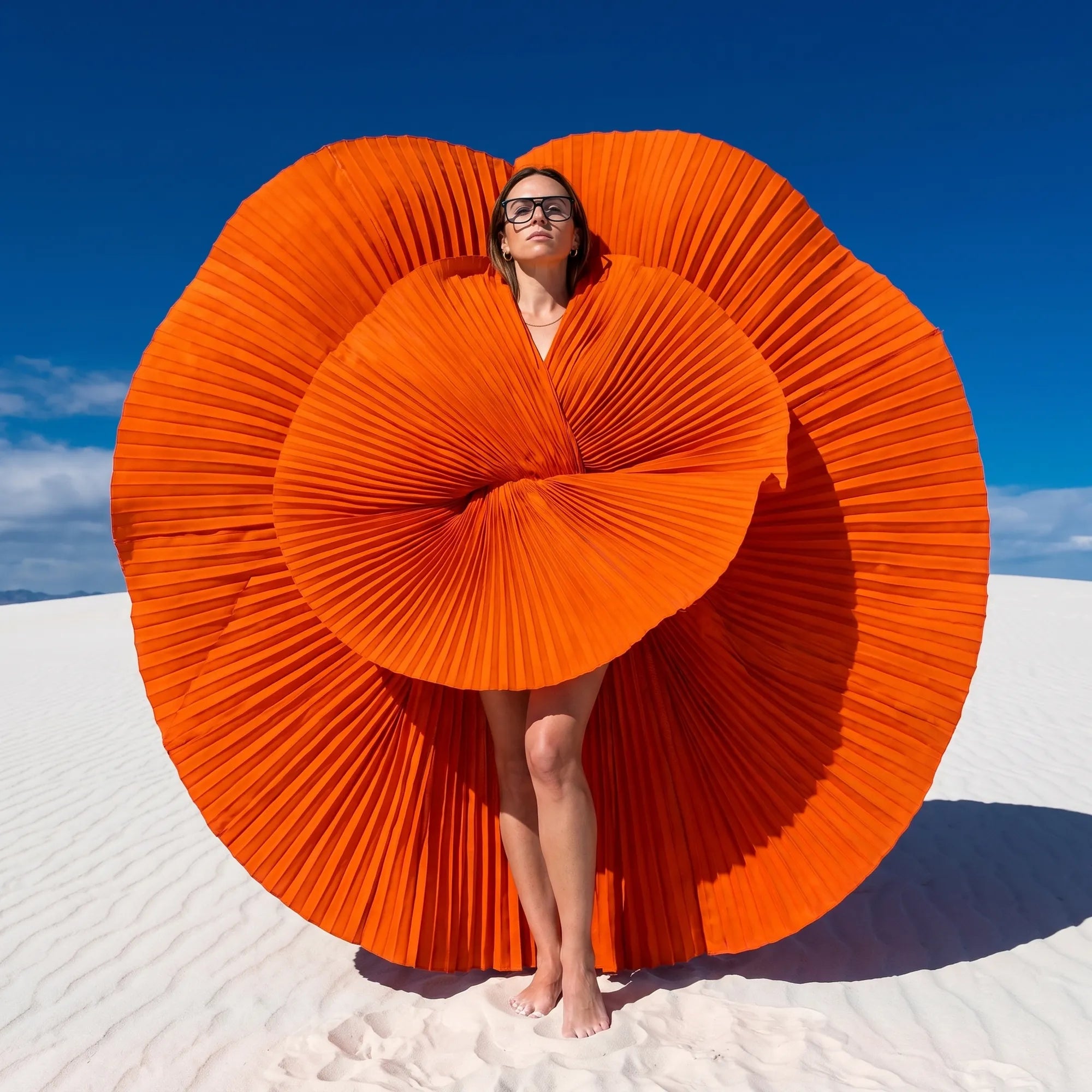 Anteojos Fiore 10177 en verde, en modelo – retrato de campaña, abanico plisado naranja escultórico sobre dunas blancas