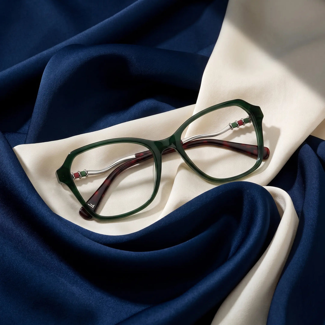 Anteojos Fiore 1030 en verde – resting on draped midnight blue and ivory silk
