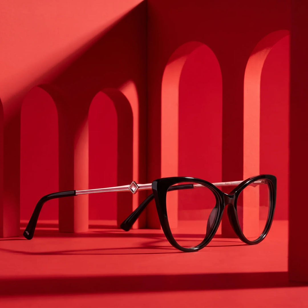 Anteojos Fiore 1031 en negro – displayed on a vivid red podium among arches