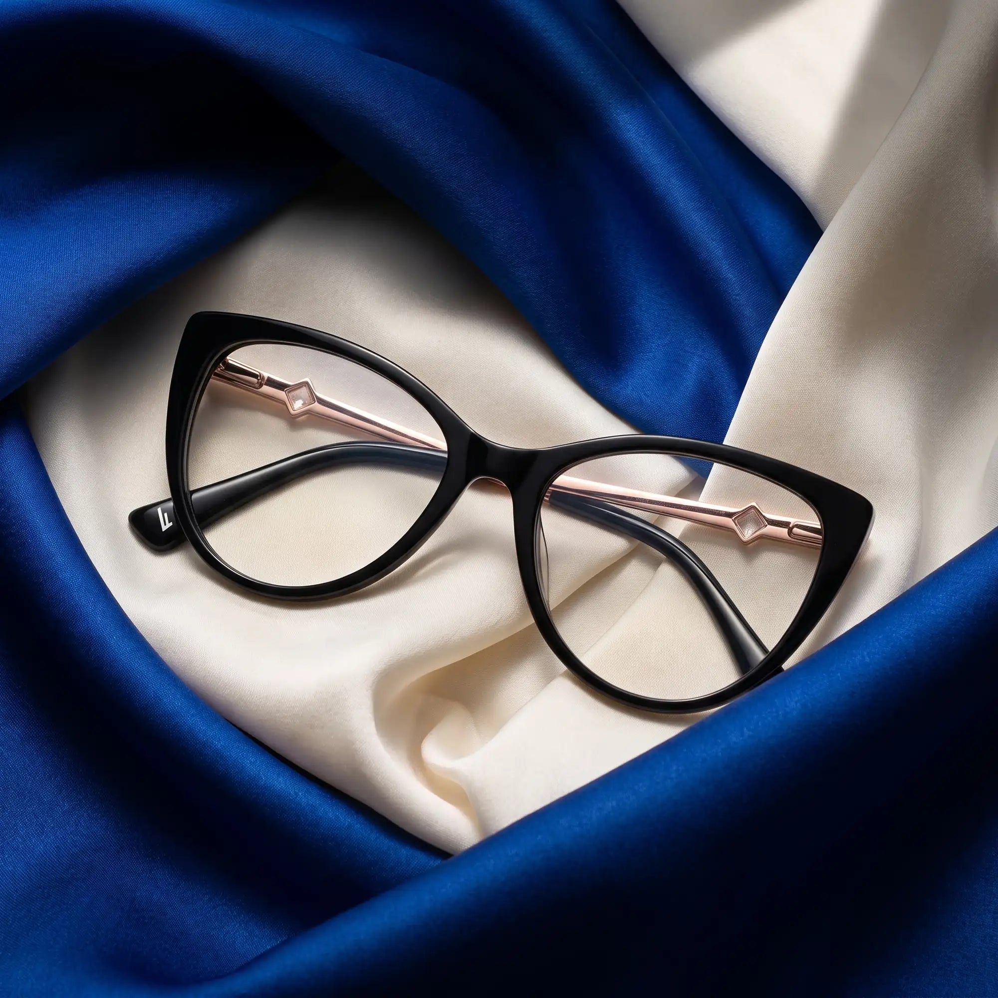 Anteojos Fiore 1031 en negro – sobre seda cobalto y marfil drapeada