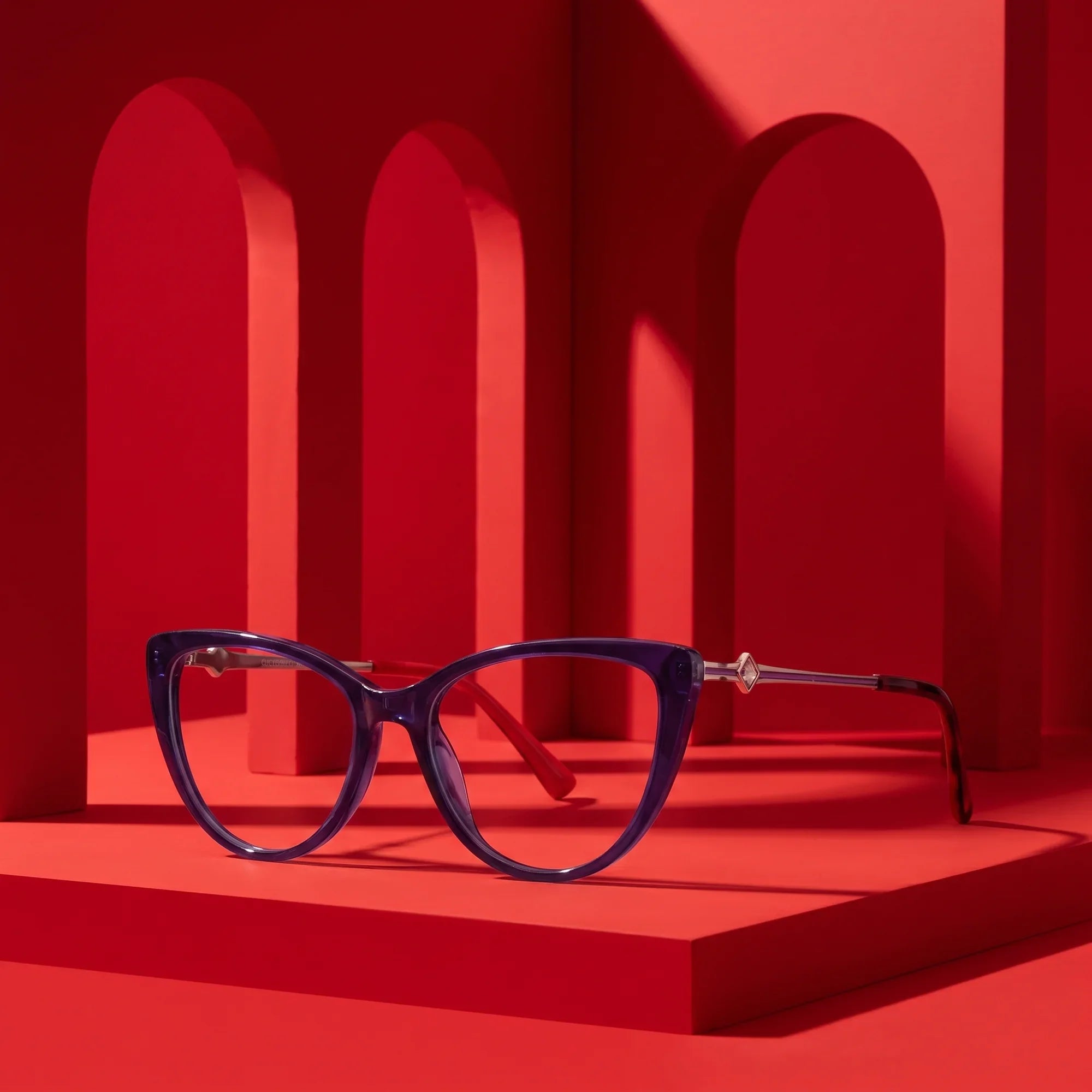 Anteojos Fiore 1031 en purple green – displayed on a vivid red podium among arches