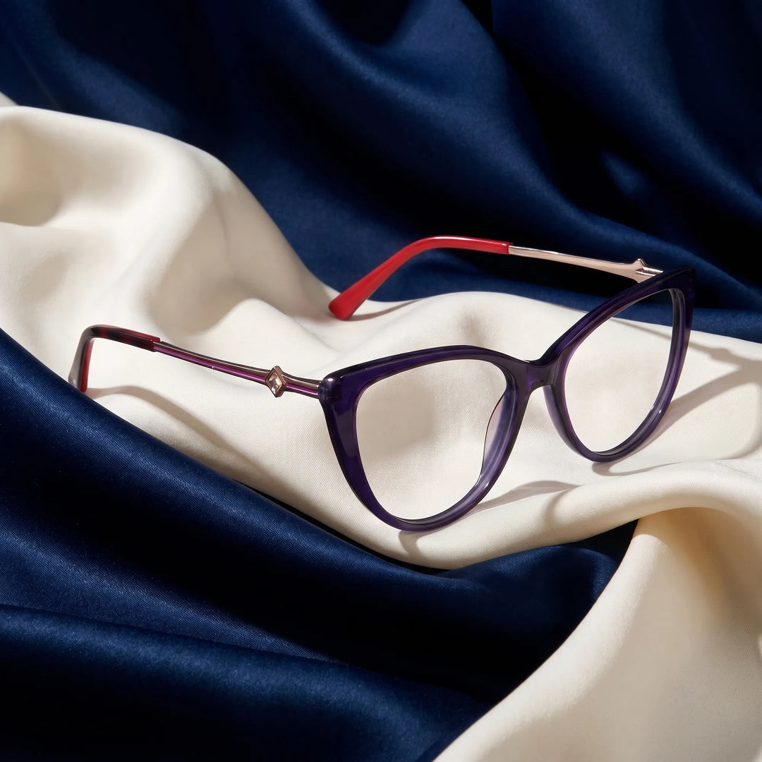 Anteojos Fiore 1031 en purple green – resting on draped midnight blue and ivory silk