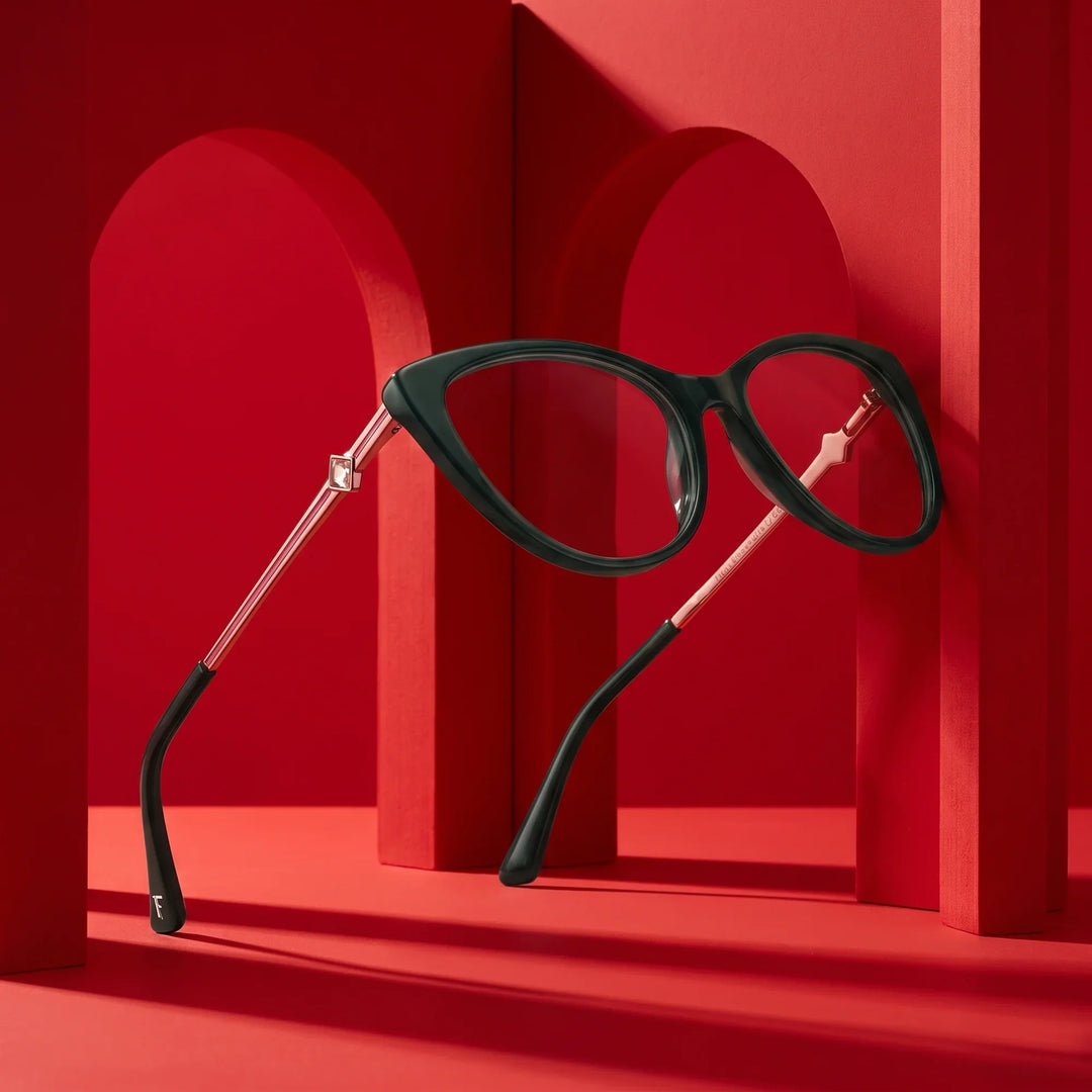Anteojos Fiore 1031 en verde – displayed on a vivid red podium among arches