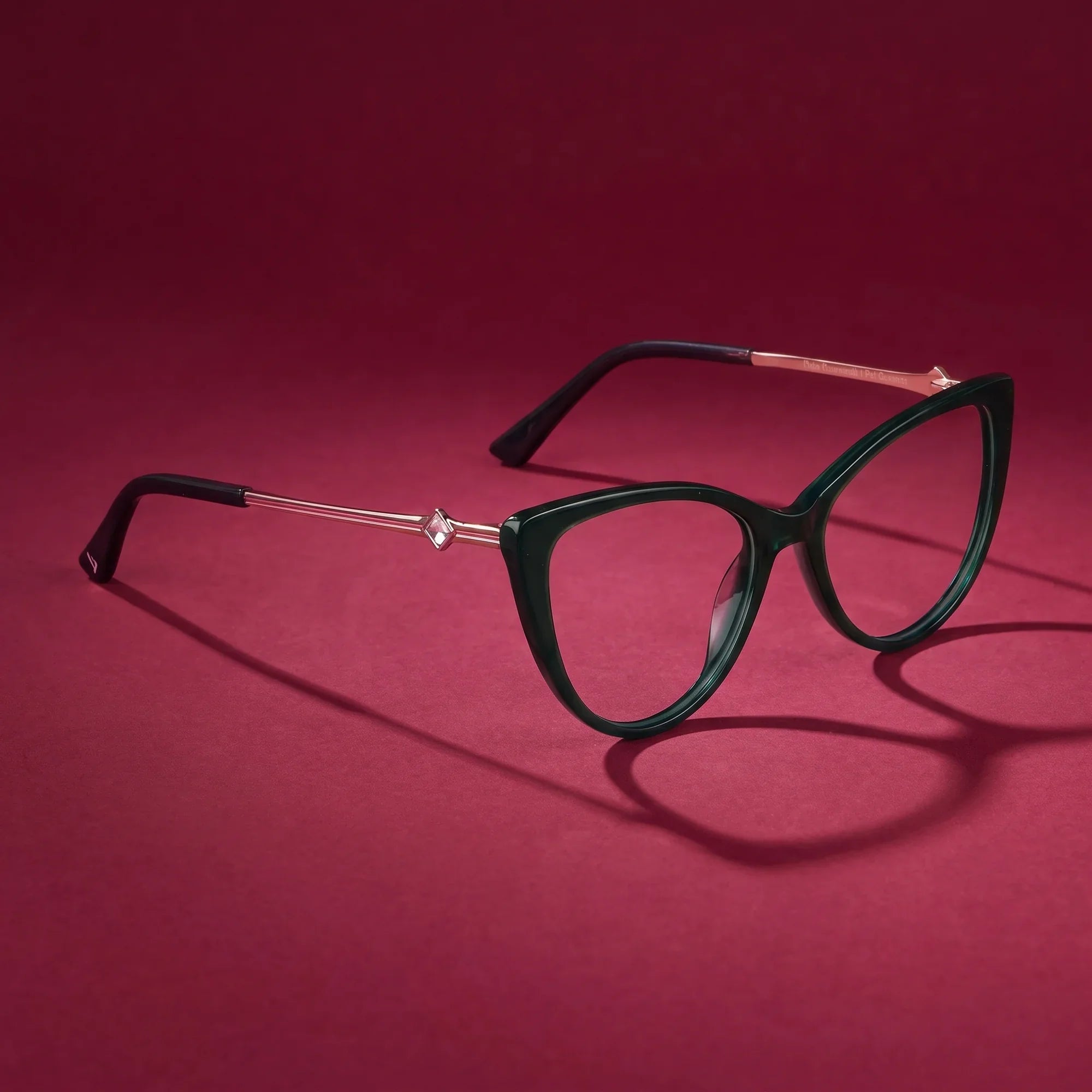 Anteojos Fiore 1031 en verde – still life on a seamless burgundy studio backdrop