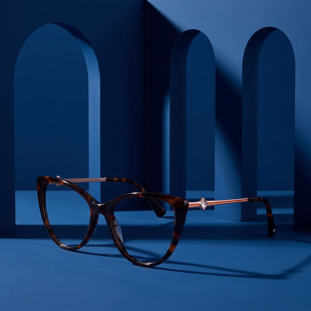 Anteojos Fiore 1031 en tortoiseshell – exhibido en un podio azul medianoche entre arcos