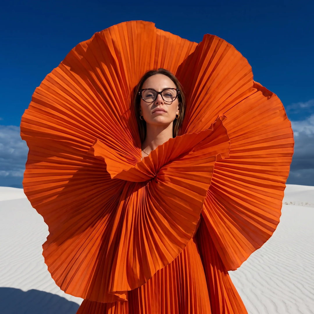 Anteojos Fiore 1031 en tortoiseshell, en modelo – retrato de campaña, abanico plisado naranja escultórico sobre dunas blancas