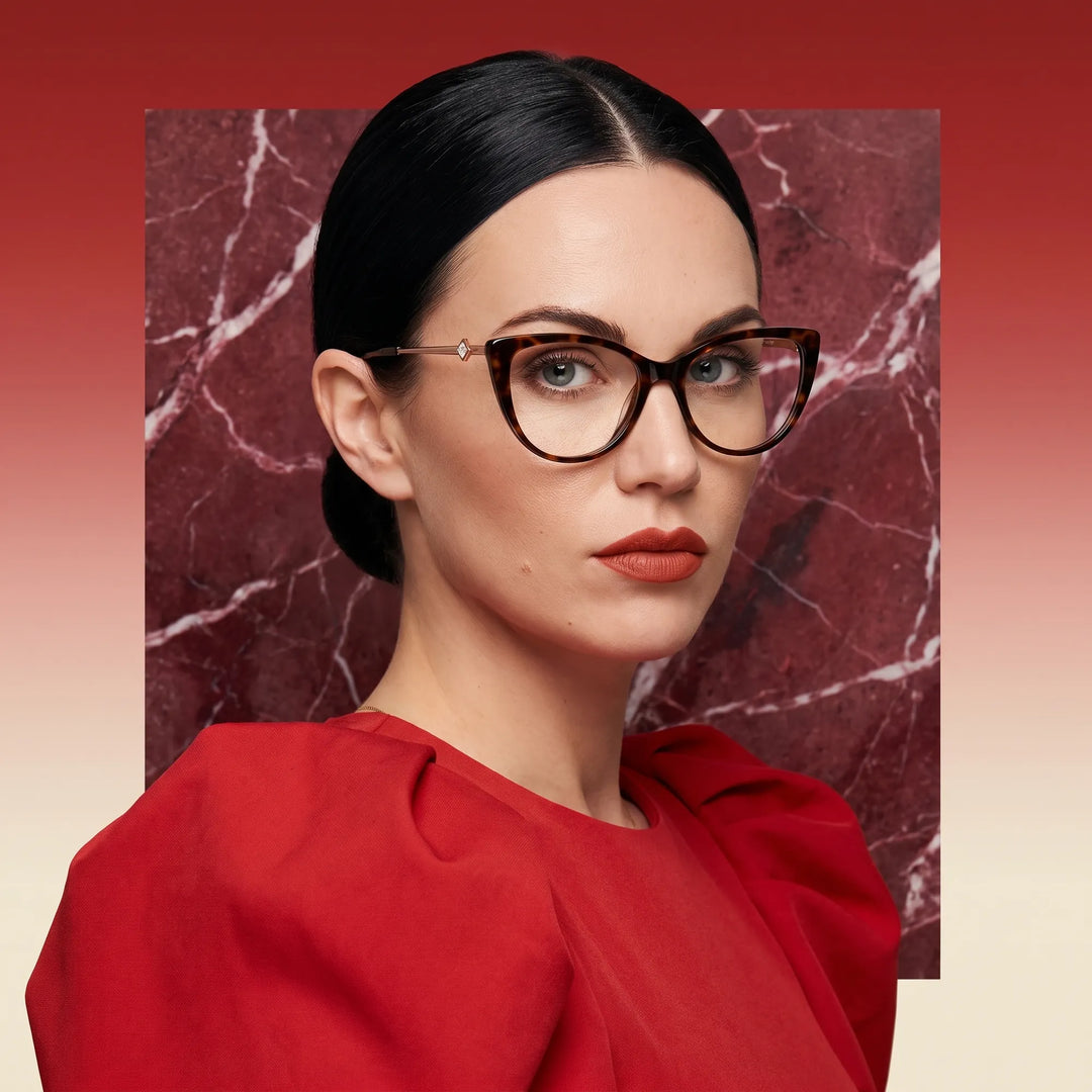 Anteojos Fiore 1031 en carey, en modelo – retrato de campaña, fondo de mármol rojo y vestido escarlata drapeado