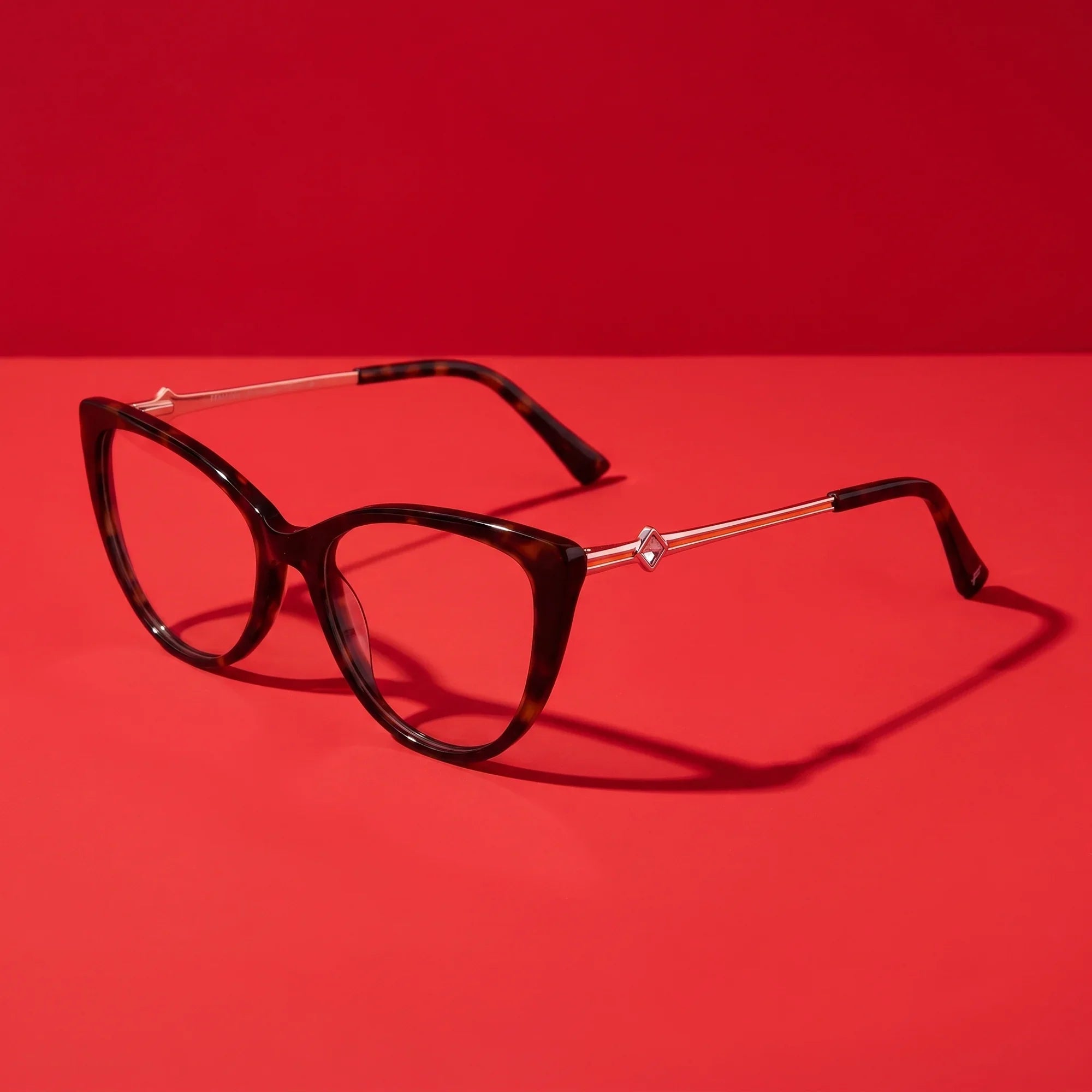 Anteojos Fiore 1031 en tortoiseshell – editorial still life on a saturated vivid red set