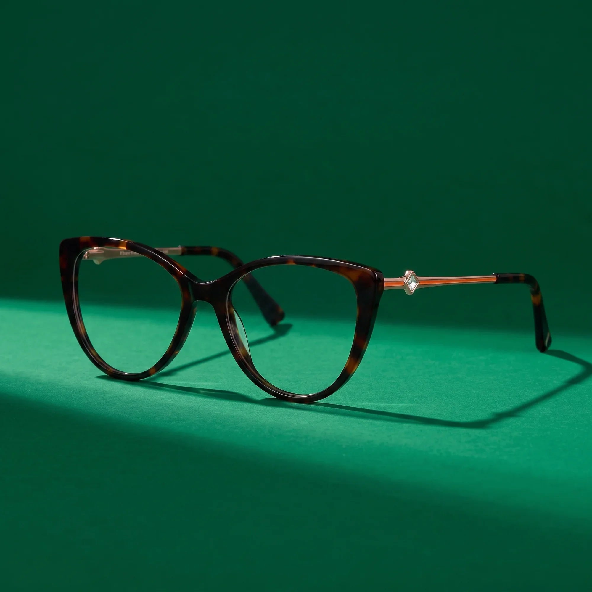Anteojos Fiore 1031 en tortoiseshell – still life on a seamless emerald studio backdrop