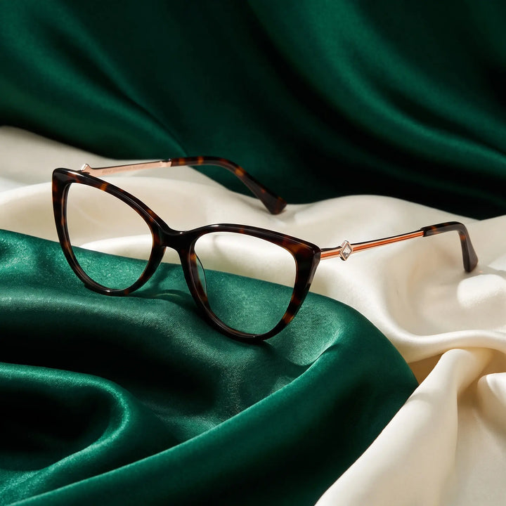 Anteojos Fiore 1031 en tortoiseshell – resting on draped emerald and ivory silk