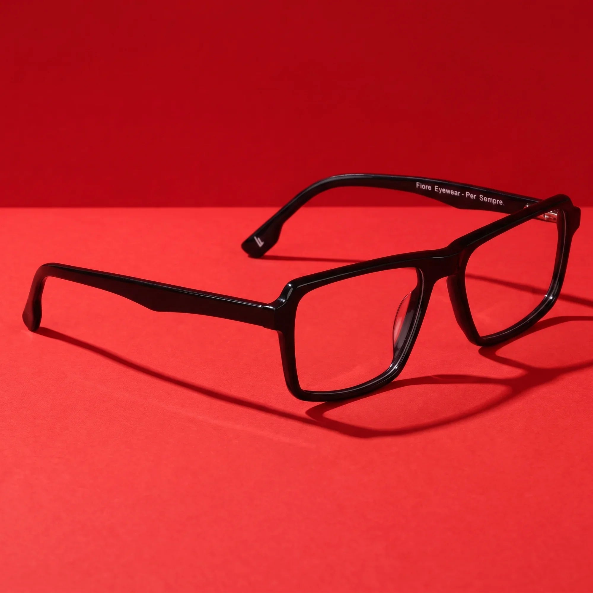 Anteojos Fiore 1038 en negro – editorial still life on a saturated vivid red set