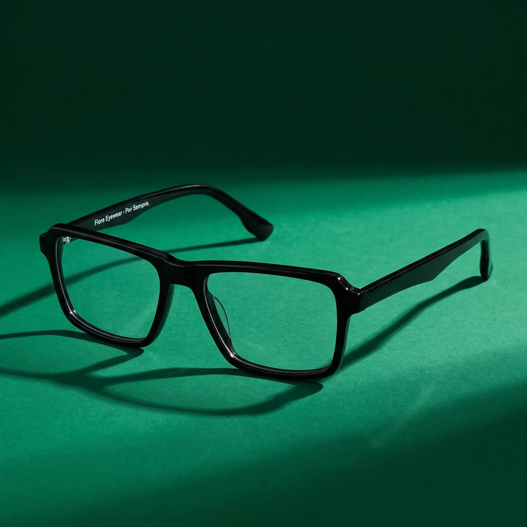 Anteojos Fiore 1038 en negro – still life on a seamless emerald studio backdrop
