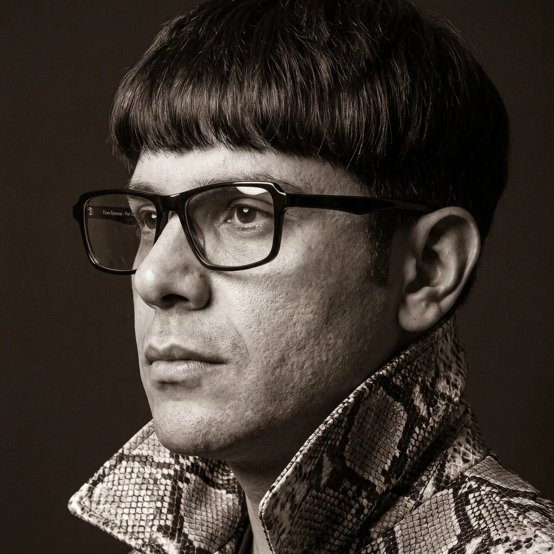 Anteojos Fiore 1038 en negro, en modelo – retrato de campaña, monochrome studio portrait, red graphic accents