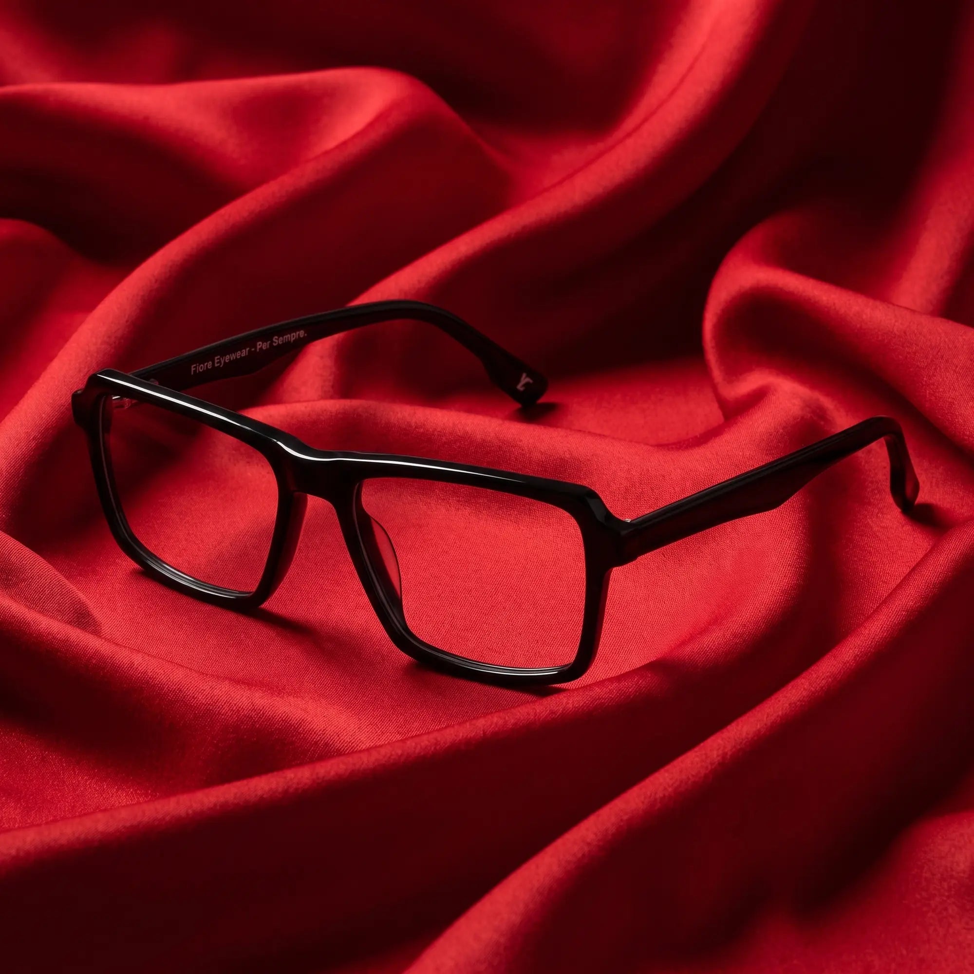 Anteojos Fiore 1038 en negro – nested in flowing vivid red silk