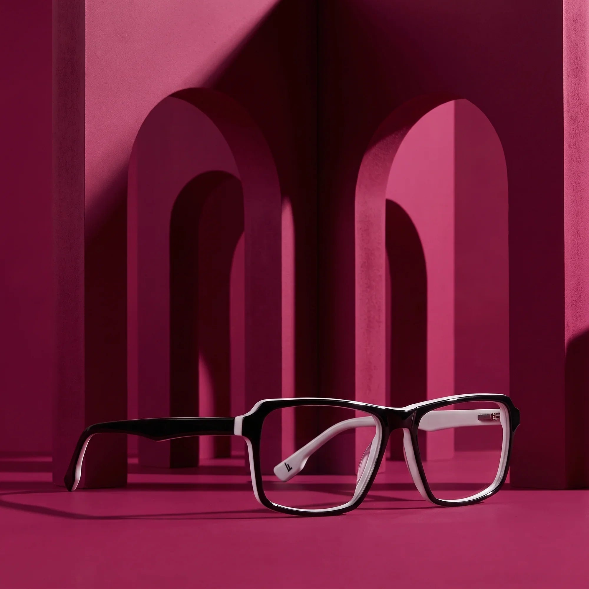 Anteojos Fiore 1038 en black white – staged on a sculptural magenta architecture set