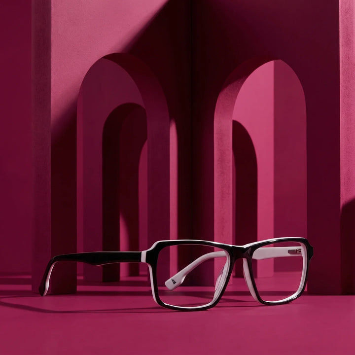 Anteojos Fiore 1038 en negro blanco – staged on a sculptural magenta architecture set