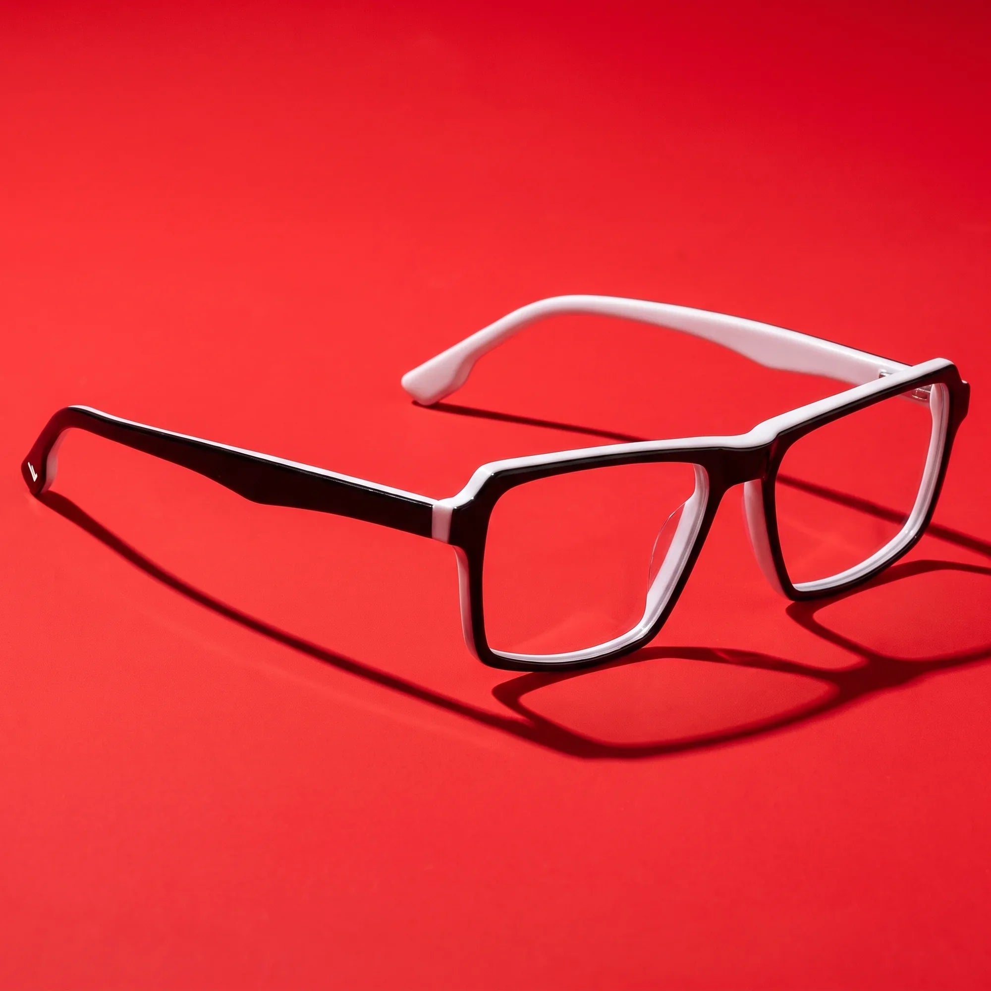Anteojos Fiore 1038 en black white – editorial still life on a saturated vivid red set
