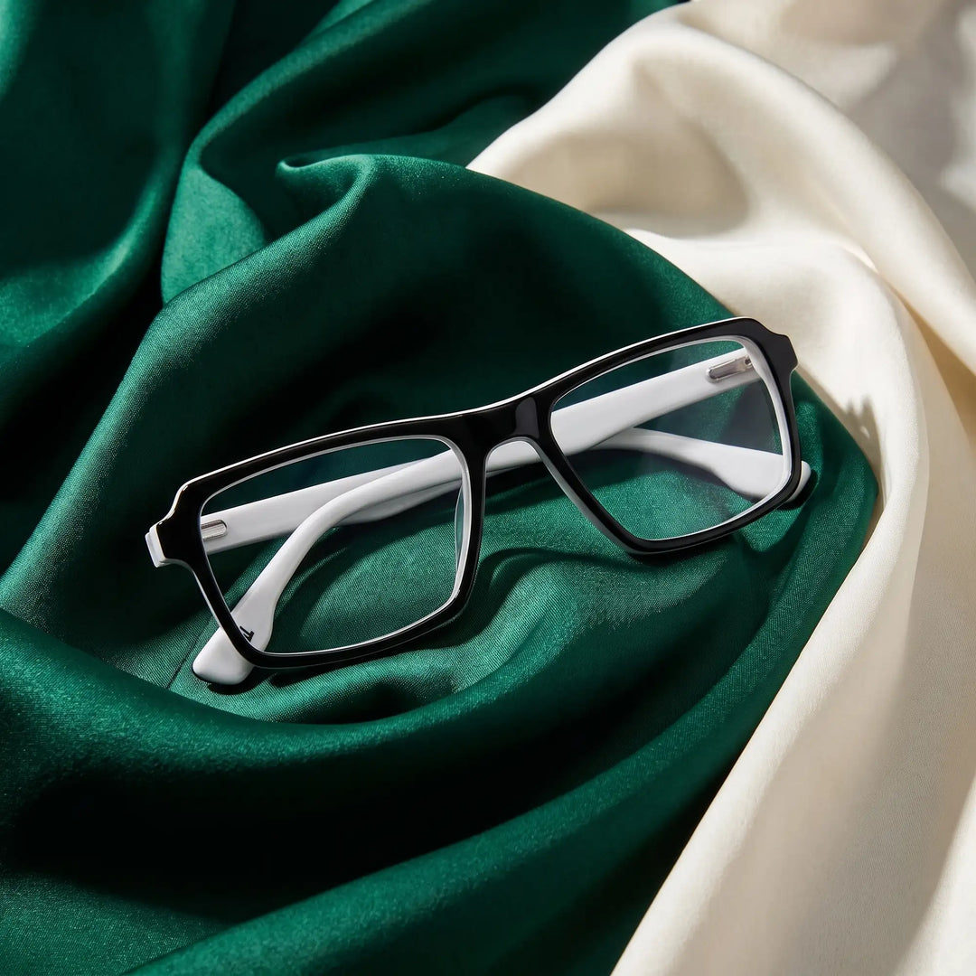 Anteojos Fiore 1038 en black white – resting on draped emerald and ivory silk