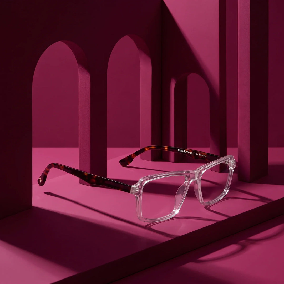 Anteojos Fiore 1038 en transparente – displayed on a magenta podium among arches
