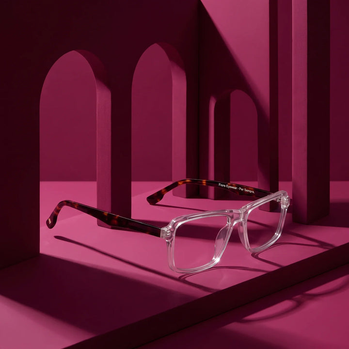 Anteojos Fiore 1038 en transparente – displayed on a magenta podium among arches