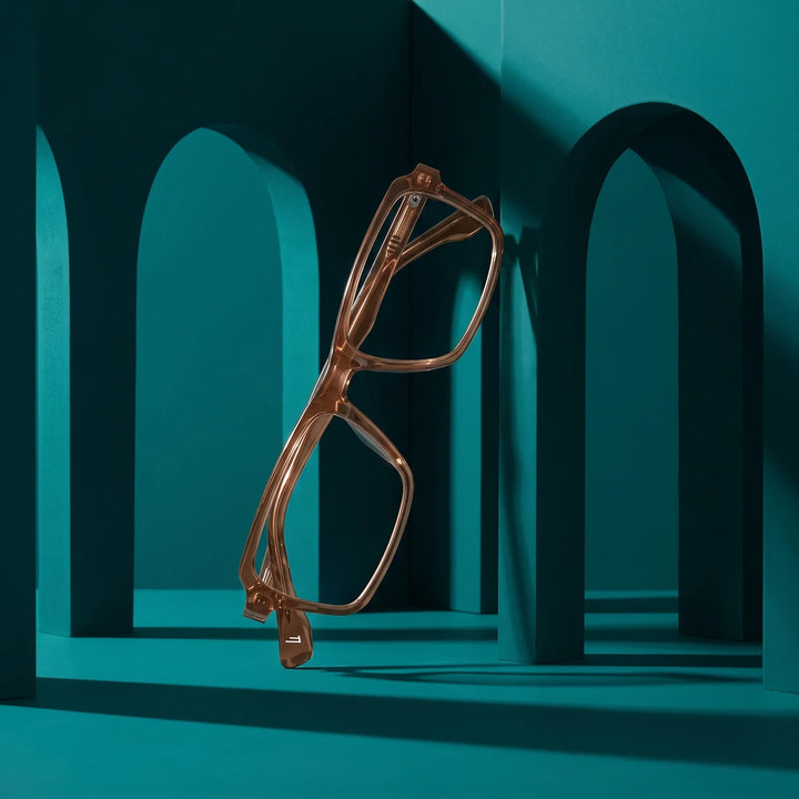 Anteojos Fiore 1038 en café – staged on a sculptural teal architecture set