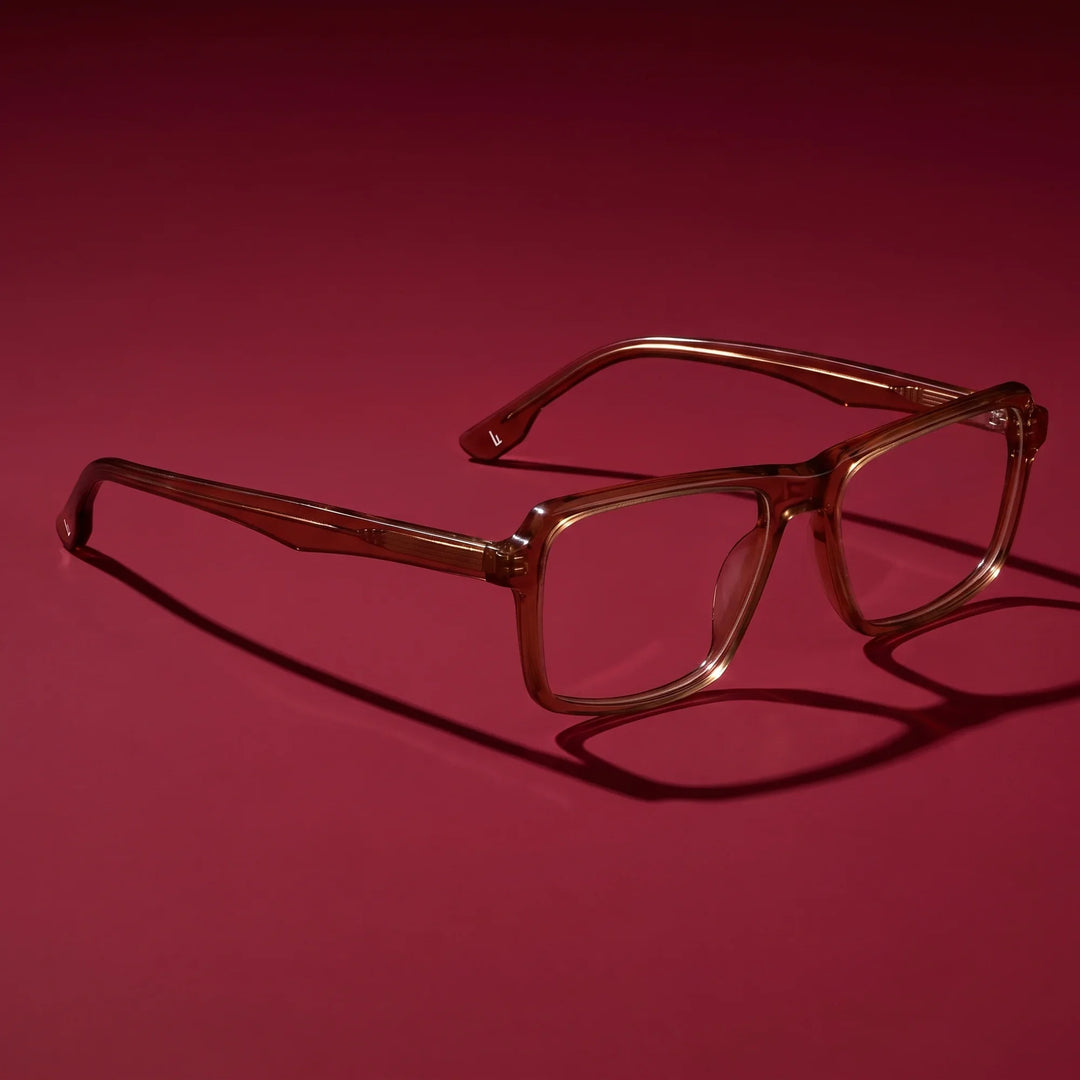 Anteojos Fiore 1038 en café – editorial still life on a saturated burgundy set