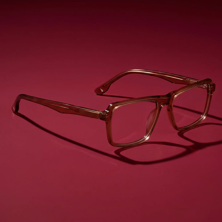 Anteojos Fiore 1038 en café – editorial still life on a saturated burgundy set