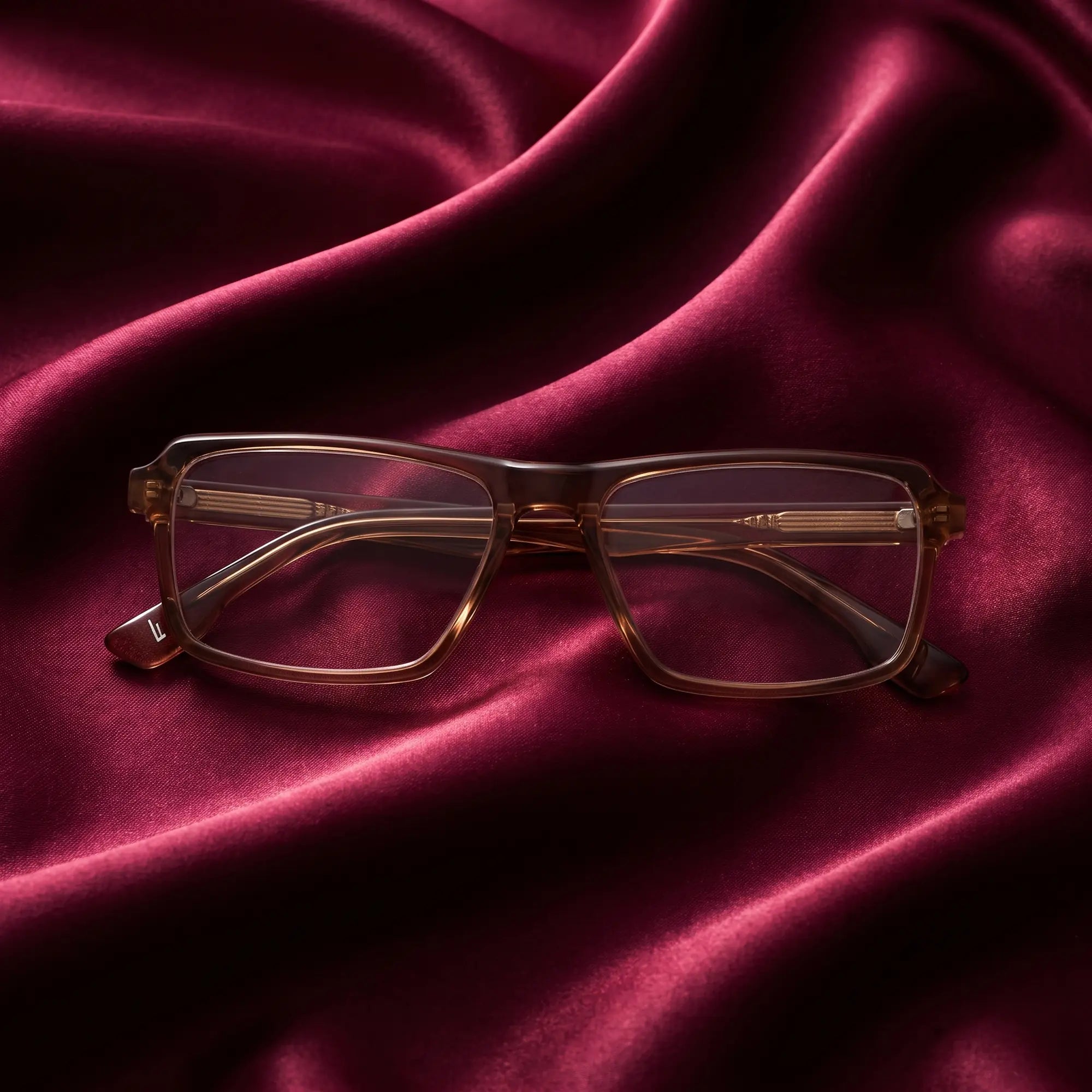 Anteojos Fiore 1038 en café – nested in flowing burgundy silk