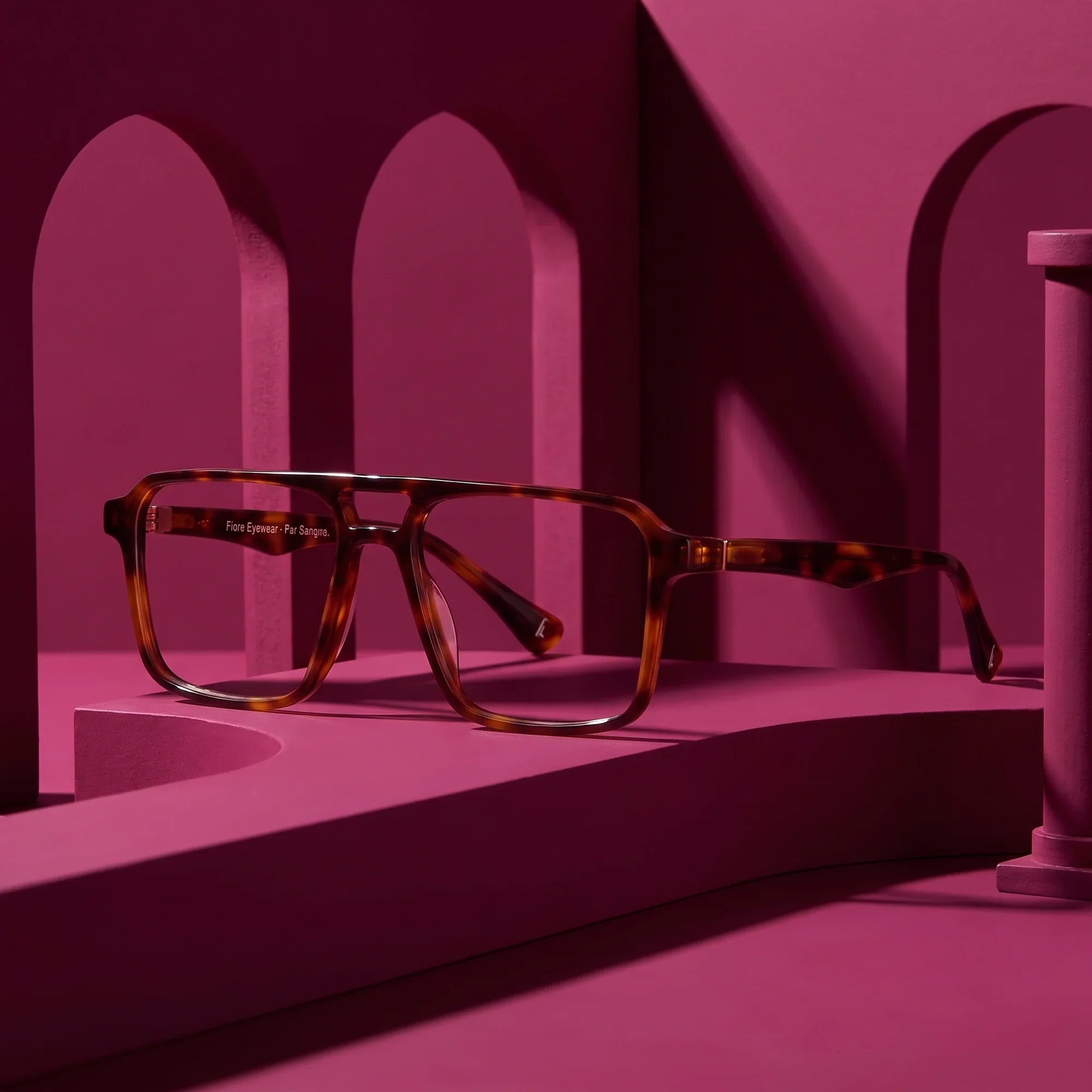 Anteojos Fiore 1039 en tortoiseshell – staged on a sculptural magenta architecture set
