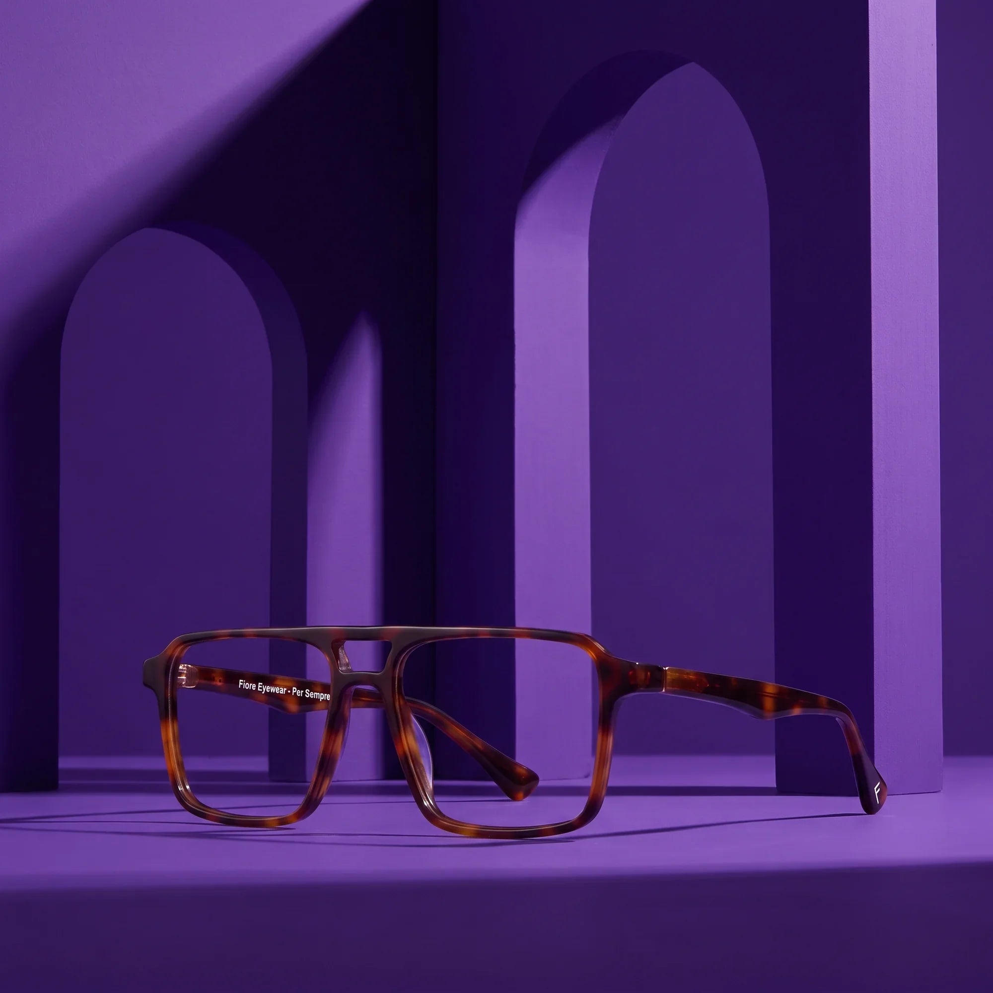 Anteojos Fiore 1039 en tortoiseshell – displayed on a violet podium among arches