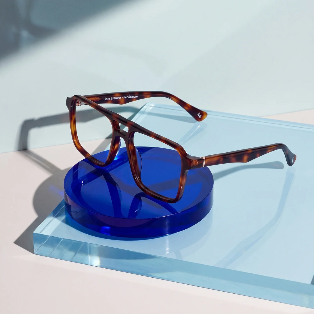 Anteojos Fiore 1039 en tortoiseshell – sobre un disco acrílico cobalto con luz suave