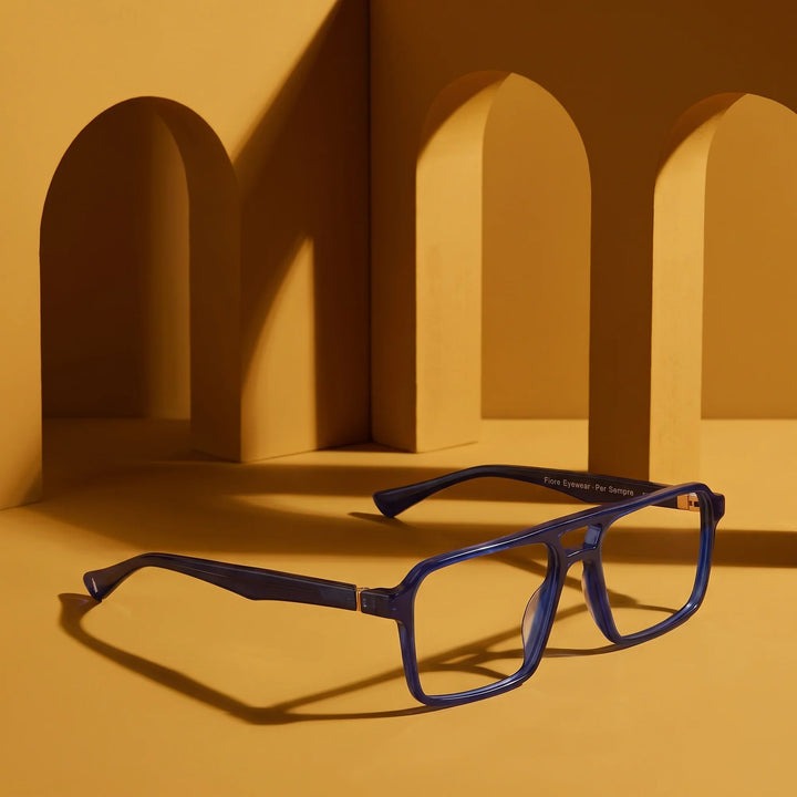 Anteojos Fiore 1039 en azul – displayed on a mustard ochre podium among arches